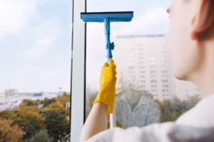 Man cleaning window with squeegee