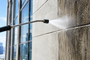 Commercial building facade being pressure washed by a certified technician